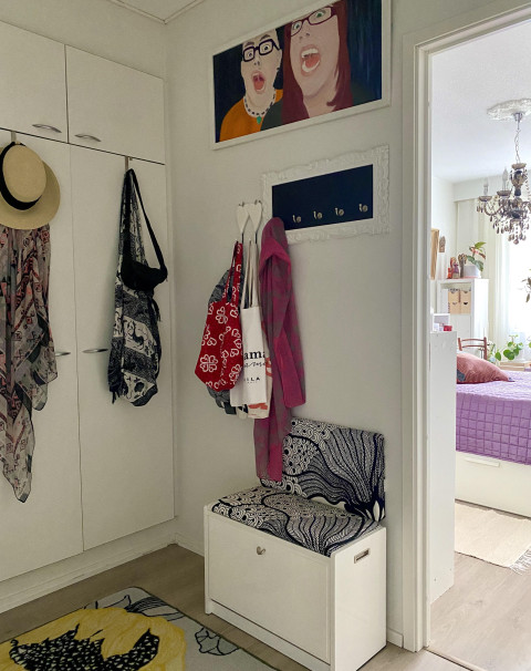 Eteisen kaapit, vaatteita ja tauluja seinällä. Kuva Heidi Lehto